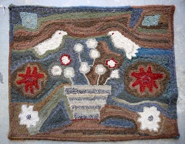 Folk art pictorial hooked rug decorated with a pot of flowers below 2 birds and flanked by flowers,