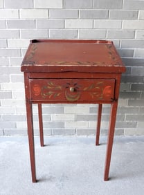 A primitive hand painted country store desk with single drawer and tapered legs. Decorated with