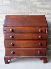 A Chippendale cherry slant front desk having a fitted interior with drawers, and cubby holes, over 4
