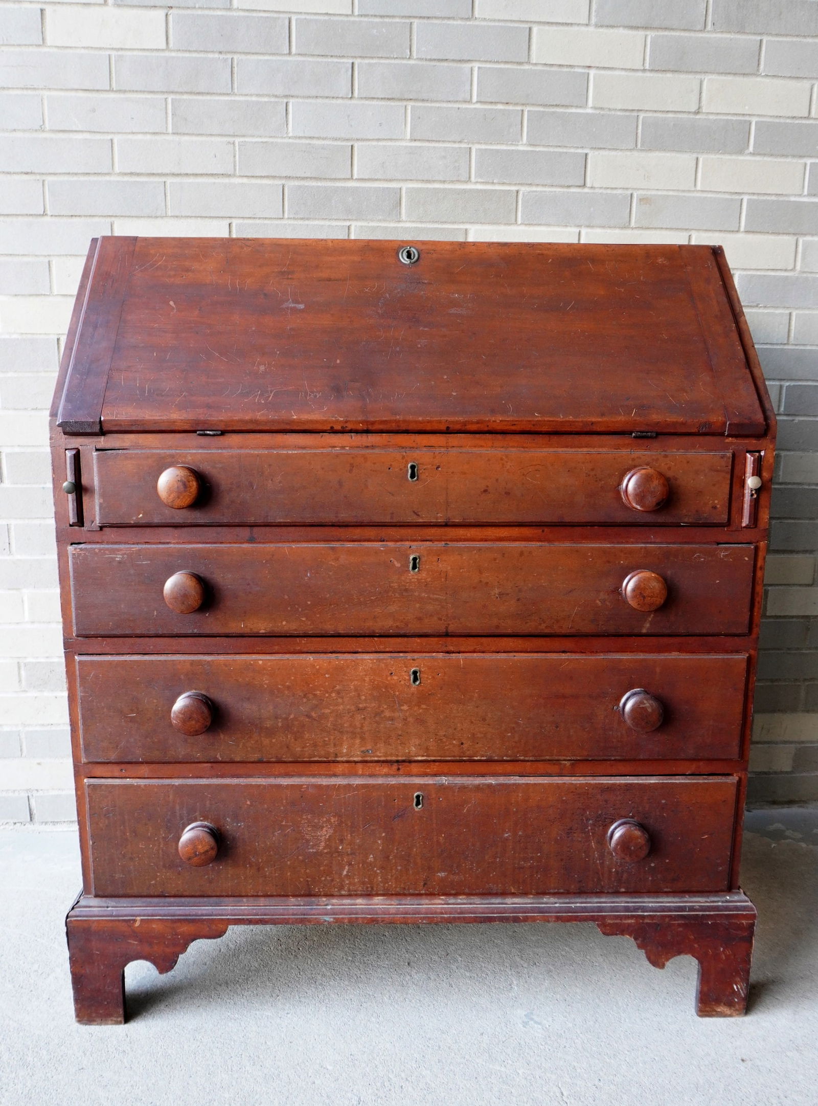 A Chippendale cherry slant front desk having a fitted interior with drawers, and cubby holes, over 4 (1 of 18)