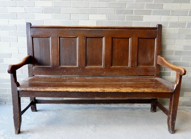 A good early primitive settle bench in original red stain with paneled back, shaped arms, 2 board