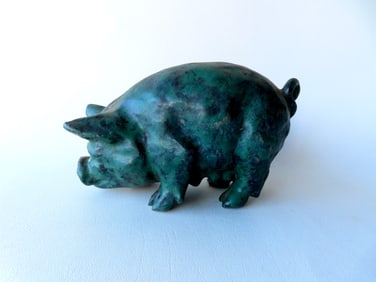 An unusual redware hand made pig with a mottled green glaze, probably 19th century. Very good