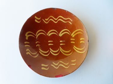 A redware plate with yellow slip decoration and coggled edge, early to mid 19th century - some small