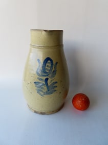 A large unusual stoneware pitcher decorated with a cobalt blue flower, with applied handle, slightly