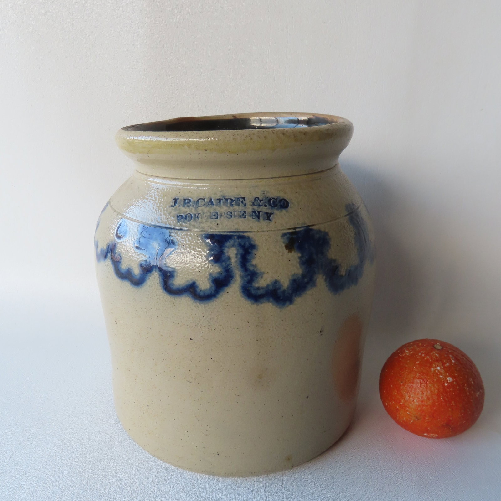A stoneware jar marked J.B. Caire & Co. Pokeepsie N.Y.: with a cobalt blue squiggly line around edge: A stoneware jar marked J.B. Caire & Co. Pokeepsie N.Y.: with a cobalt blue squiggly line around edge of shoulder - very good condition, no damage - probably 1 gallon size - measures 9"H x 8" diameter.