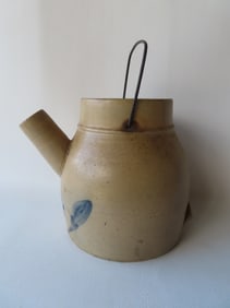 A stoneware batter pitcher, probably 1 gallon size, decorated with a cobalt blue flower under spout