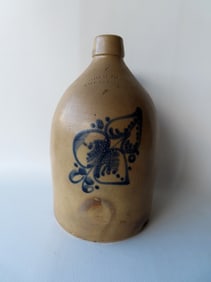 Stoneware jug marked "Adam Caire /  PoKeepsie. N.Y." decorated with a large cobalt blue flower.