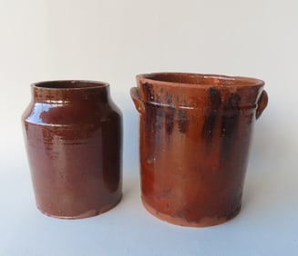 Two redware jars. The first a jar with applied ears and manganese decorations - chips and glazing