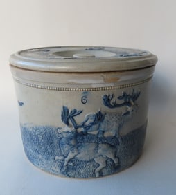 A White's Utica stoneware covered butter crock decorated with embossed hunters and deer with cobalt