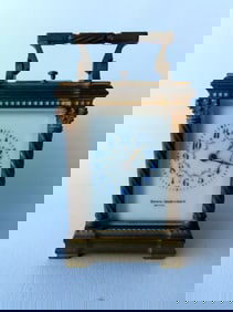 A bronze or brass carriage clock with enameled face, marked "Shreve, Crump & Low Co. /  Boston" on