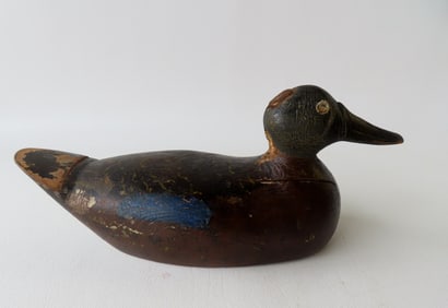 A folk art carved wooden decoy, 3/4 size, crusty old paint with carved beak and inset lead weight on