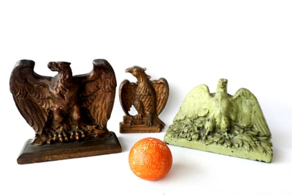 Three spread wing eagle collectibles, including: A cast iron eagle door stop attached to wooden base
