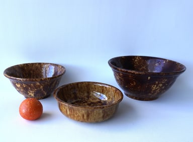 Three Bennington mixing bowls, 19th century. The 2 largest on footed bases with embossed decorations
