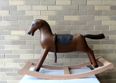 A hand made folk art hobby horse in original brown and black paint and original saddle and stirrups.