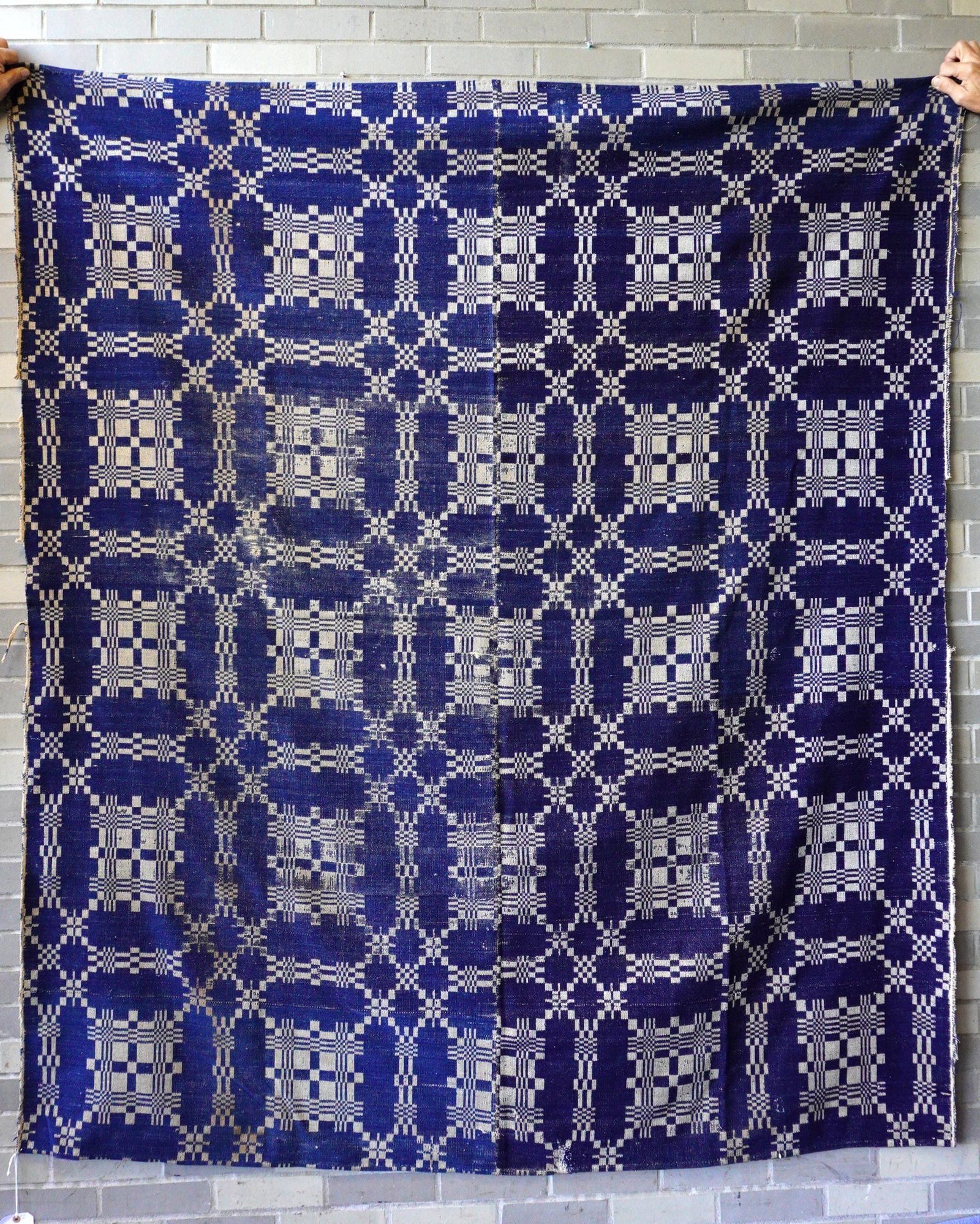 A blue and white coverlet with century seam, geometric pattern, some use wear but overall fair to: A blue and white coverlet with century seam, geometric pattern, some use wear but overall fair to good condition, early 19thy century, 80" x 71".