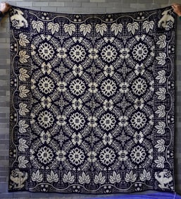 A blue and white Jacquard 2 part coverlet decorated with spread wing eagles in the corners, leaf on