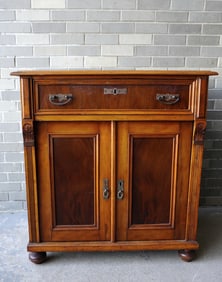 A Victorian jelly cupboard having 1 drawer over 2 paneled doors. The front feet are turned and the