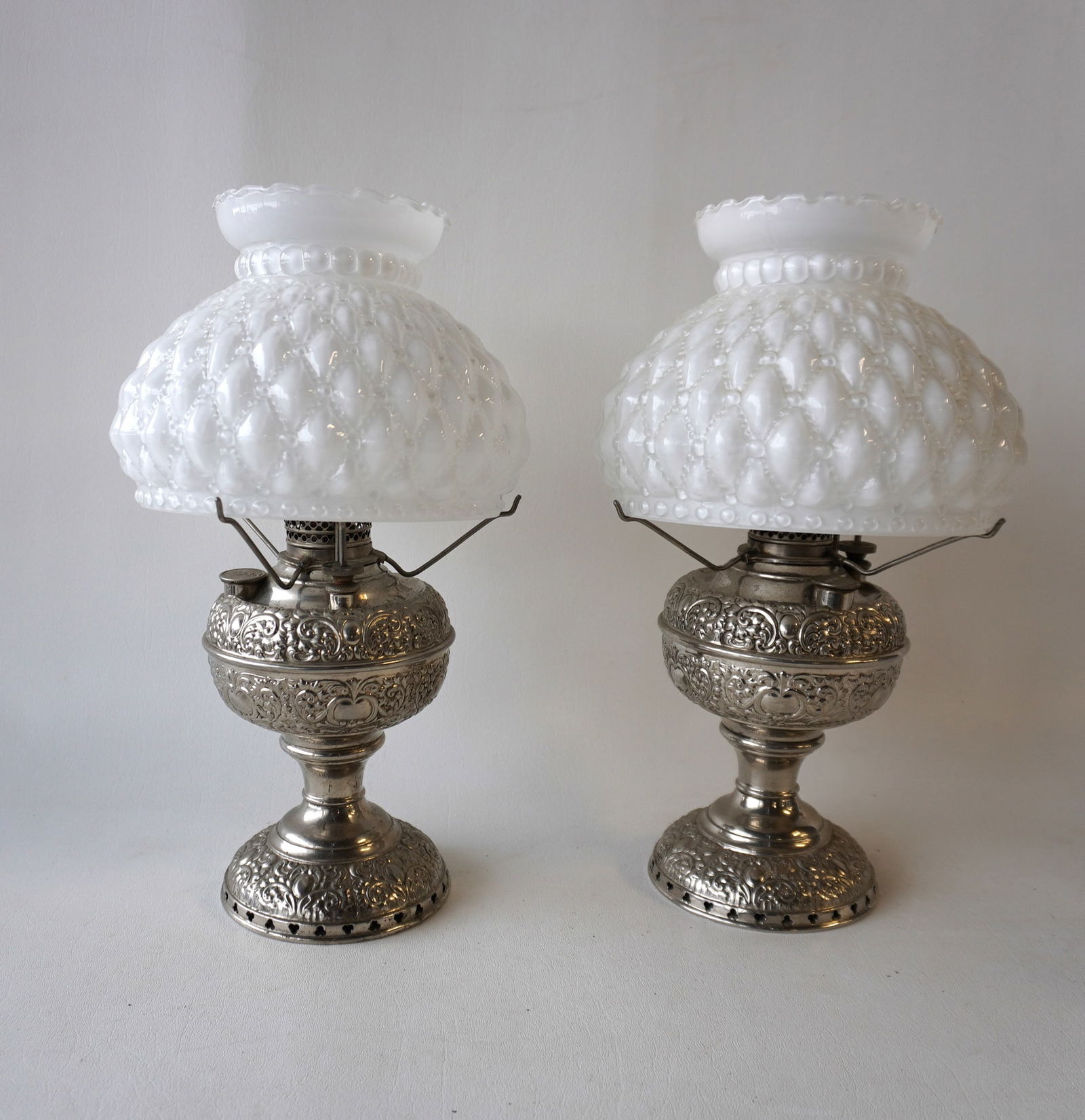 Two fancy matching Miller nickel plated oil lamps with matching shades. Signed "The Miller Lamp /: Two fancy matching Miller nickel plated oil lamps with matching shades. Signed "The Miller Lamp / Made in U.S.A.", circa 1880-90 and in very good condition. Both with later shades, and missing one chi