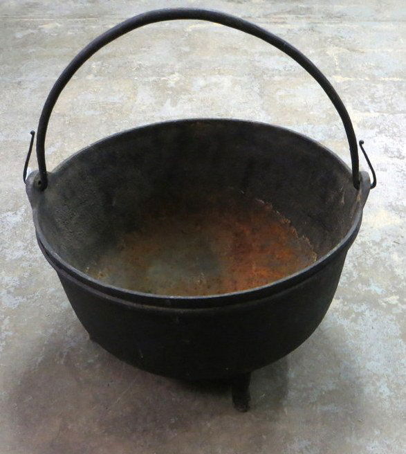 Large footed cast iron cauldron with hand forged h: Large footed cast iron cauldron with hand forged handle - 21.5"D.