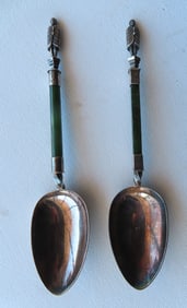 Two hallmarked sterling silver and jade serving spoons having New Zealand Maori Warrior finials,