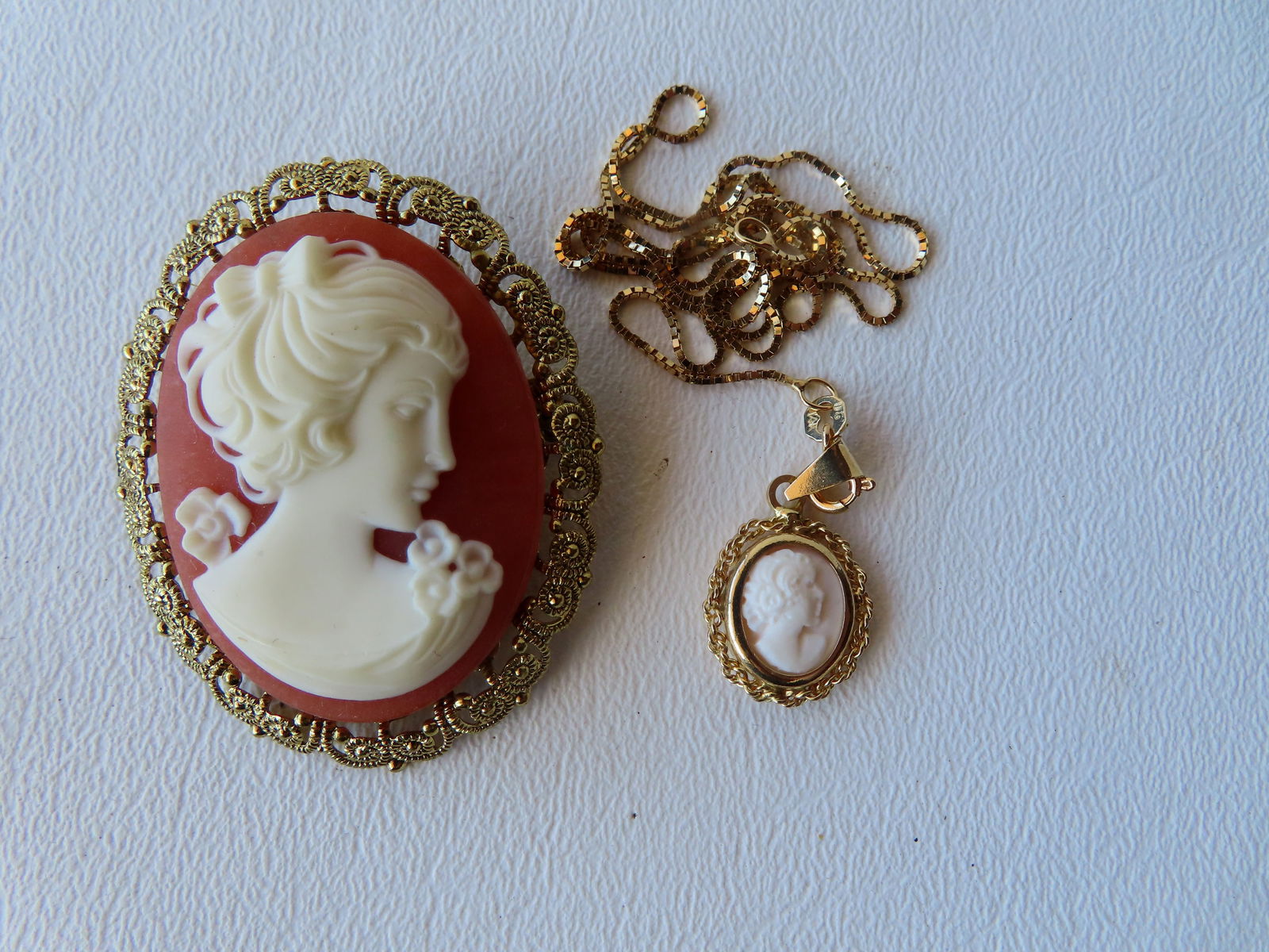 Two cameos including: A pink cameo with 14k gold mount and chain, made in Italy by Rossana; and a (1 of 5)