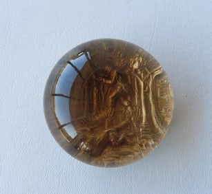 An unusual glass paperweight with a gilded relief sculpture of hunter and dog, mounted on a metal