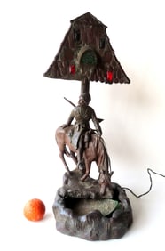 An Arts & Crafts period faux bronze table lamp (white metal with bronze surface), depicting a