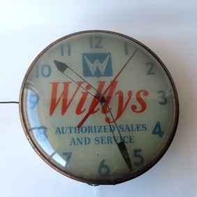 A Willys Jeep advertising clock marked "Willys Authorized Sales and Service". Some wear to the
