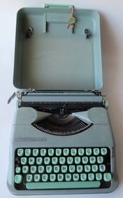 A Hermes "Rocket" portable typewriter in plastic case, light green. The top of the typewrite with