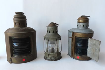 Three nautical related lanterns including: Metal lamp with original oil burner, colorless lens, good