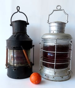 Two large ship anchor lanterns. One with red glass lens, metal frame in old gray paint - missing