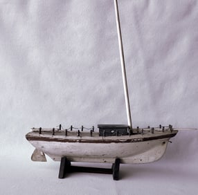 A handmade sailboat model with operational rudder and in old paint, early 20th century. Missing