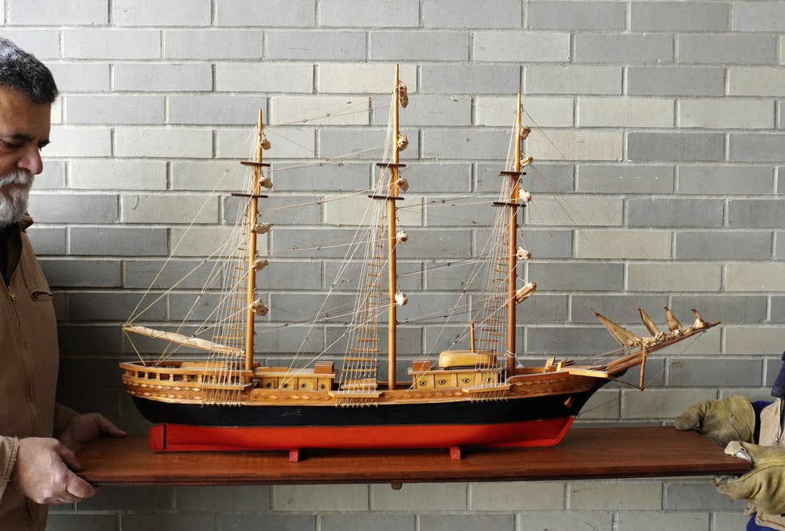 A fully rigged 3 mast sailing vessel with tied down sails, hull in original red and black paint -: A fully rigged 3 mast sailing vessel with tied down sails, hull in original red and black paint - some crazing, and mounted on a wooden plank. Very good condition. The boat measures 44"L x 28"H x 10"W