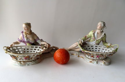 A pair of matching Meissen porcelain reclining figures of man and woman with open weave baskets,