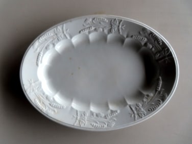 An early ironstone platter decorated with embossed wheat around the border - "Canada" pattern signed