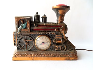 An electric clock - night light, in the form of a steam engine with red lights and an articulated