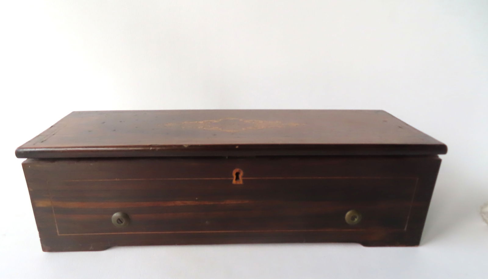 A rosewood cylinder Swiss music box, 8 tunes, with original printed operating instructions on paper: A rosewood cylinder Swiss music box, 8 tunes, with original printed operating instructions on paper marked "M. J. Paillard, Importers of Watches and Music Boxes, 21 Maiden Lan, New York". Cylinder and