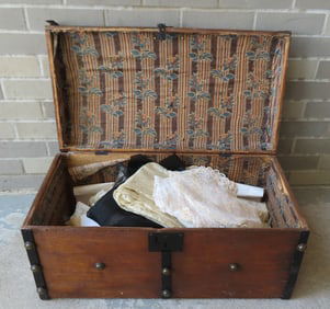 A stagecoach trunk filled with linens and lace textiles, some in French cut, 19th/20th century. Most