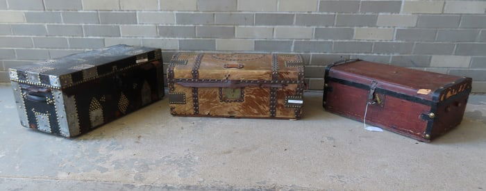 Three 19th century leather and cowhide trunks, 2 with wall papered interiors and all with tack