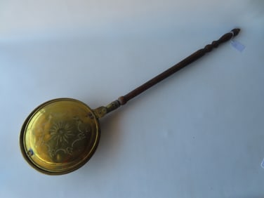 A brass and iron bedwarmer with turned wooden handle , early to mid 19th century. The brass lid