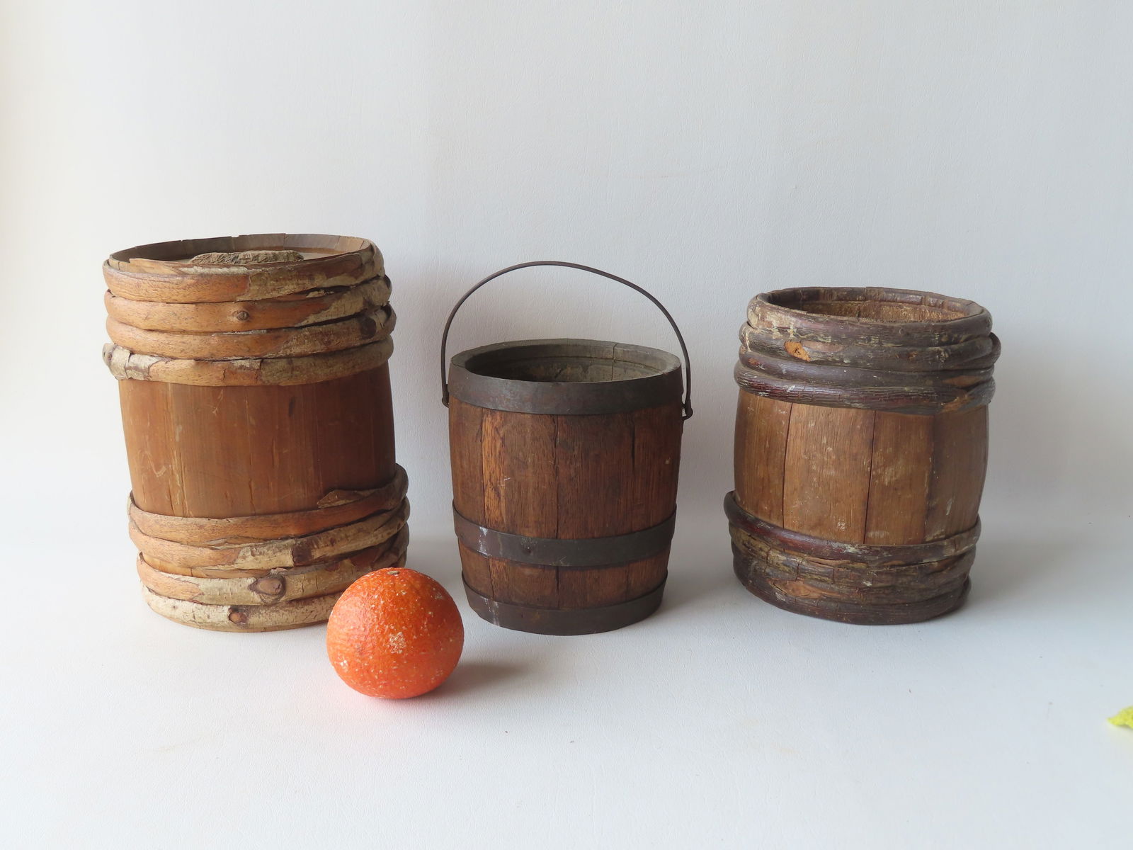 Two small primitive wooden barrels for water or gun powder, one with original stopper - the largest: Two small primitive wooden barrels for water or gun powder, one with original stopper - the largest 9 1/4"H x 7 1/4"W - both in good condition; together with a small wooden bucket with bale handle. Al
