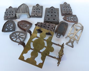 Large grouping of vintage iron trivets and an early adjustable brass and iron fireplace trivet,