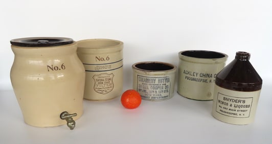 Grouping of 5 stoneware crocks and jug including a water cooler, several advertising pieces