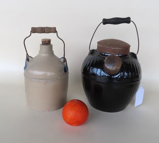 Two stoneware jugs. The first with a wire bail handle attached to embossed leaves on vine ears and