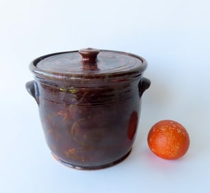 An unusual redware jar with applied handles, matching lid, in Albany glaze decorated with a lighter