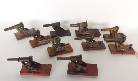 Grouping of 10 toy spring activated cap shooting cannons, circa 1900. Includes 9 in cast iron and 1