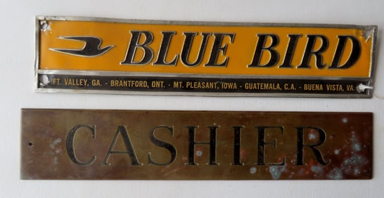 Two small advertising signs. The first a bronze "CASHIER" sign with black lettering, measuring 13