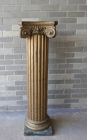 A classical carved wooden architectural Ionic style column with fluted post in gilded paint. The