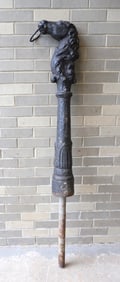 An unusual cast iron horse head hitching post with layers of old paint and having a rearing head,