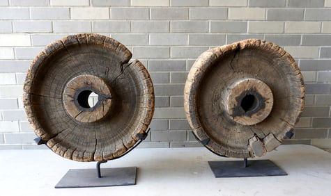 Two early wooden wagon wheels mounted on custom made museum bases for display purposes, probably